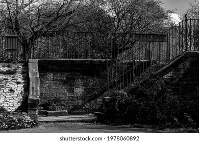 A Set Of Old Sandstone Stairs Leading Down Towards A Park