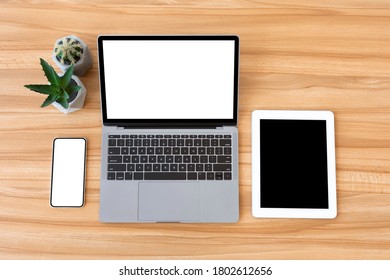 Set Of Open Laptop, Digital Tablet And White Smart Phone With Isolated Screen On Modern Wooden Desk, Free Space, Flatlay