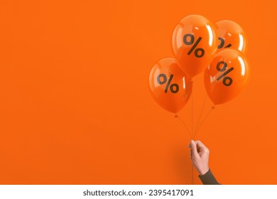 Set of orange balloons with black percent sign floating on orange background. Sale, discount and marketing concept. - Powered by Shutterstock