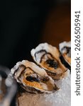 A set of oysters with additional stuffing inside. Sophisticated decor in a restaurant.