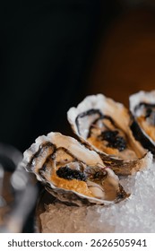 A set of oysters with additional stuffing inside. Sophisticated decor in a restaurant.