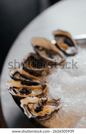 A set of oysters with additional stuffing inside. Sophisticated decor in a restaurant.