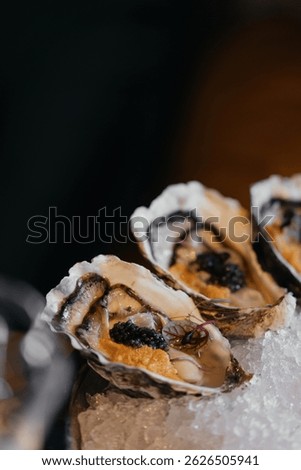 A set of oysters with additional stuffing inside. Sophisticated decor in a restaurant.