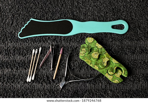 set for pedicure and\
manicure at home. tweezers, nail file, sticks and a divider for the\
hoop against the background of a gray towel. SPA at home, with your\
own hands.