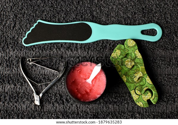 set for pedicure and\
manicure at home. tweezers, nail file, pink scrub and a divider for\
the hoop against the background of a gray towel. SPA at home, with\
your own hands.