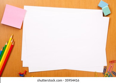 Set of pencils, erasers, post-its and other useful supplies for the school. There is a centered blank sheet for text writing - Powered by Shutterstock