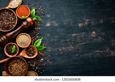 A set of peppers. Black pepper, colored pepper, ground pepper, dried chili pepper. Top view. On a black background. free space for your text. - Powered by Shutterstock