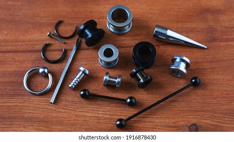 Set for piercing Piercing accessories on wooden background.