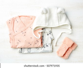 Set Of Pink Baby Clothes On Wooden Background, Top View