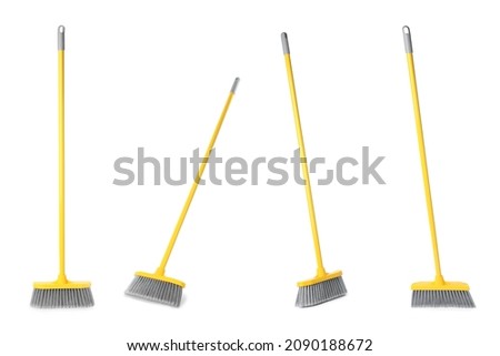 Set with plastic brooms on white background