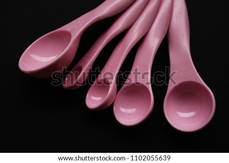 Set of plastic measuring spoon placed over dark background. The object is used to eliminate imprecision of ingredient