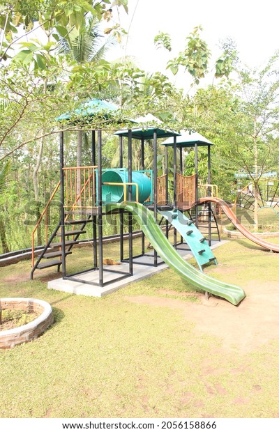 A set of play ground\
equipment consist of slides, tunnel, rope bridge, and rock climbing\
made from metal and plastic installed on a fixed concrete\
foundation.
