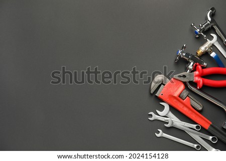 Set of plumber's items on dark background