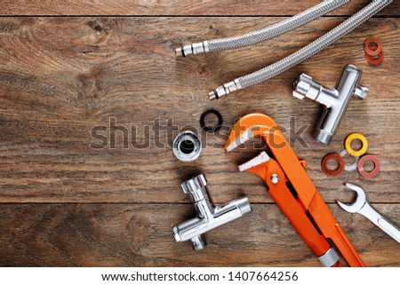 Set of plumbing tools on wooden table background. Close up top down view with copy space.