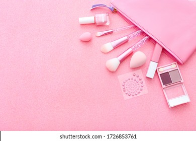 Set of professional decorative cosmetics, makeup tools and accessories on pink sparkle background. Beauty, fashion and concept. Flat lay composition, top view