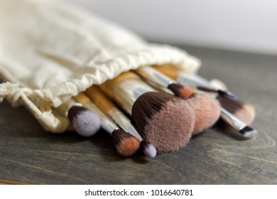 set of professional make up brushes lying into fair bag. close up photo