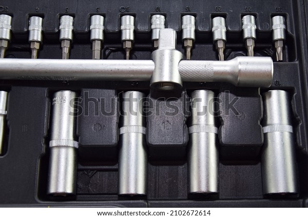 A set of professional wrenches in cradles, socket\
heads, ratchet wrench, torx. A set of ratchets with heads,\
different socket wrenches close-up in a brown plastic case. Car\
repair concept, auto deal.