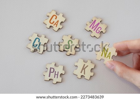 Set of puzzles with the most important macronutrients with colorful inscriptions on a beige background. Ca, Mg, Na, Cl, S, Ph, S, K. Biologically important elements.