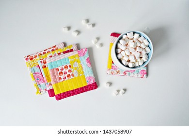 Set Of Quilted Patchwork Colorful Coasters And White Cup  With Marshmallows