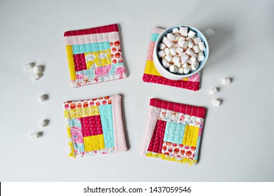 Set Of Quilted Patchwork Colorful Coasters And White Cup With Marshmallows