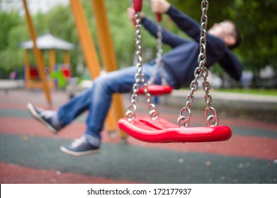 Set of red chain swings on modern kids playground