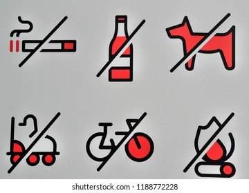 A Set Of Red Prohibition Signs. No Smoking, Drinking, Biking, No Dogs Allowed, No Skating, No Fire. White Board With Bans