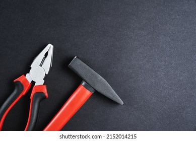 Set Of Renovation Tools. Instruments For Repair And Maintenance. Hammer And Tongs On Black Background, Top View Flat Lay