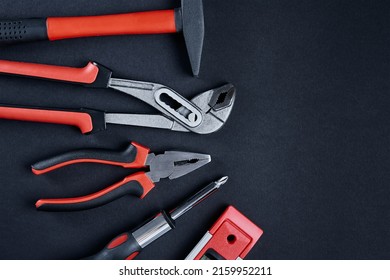 Set Of Renovation Tools. Instruments For Repair And Maintenance. Hammer, Wrench And Tongs On Black Background, Top View Flat Lay