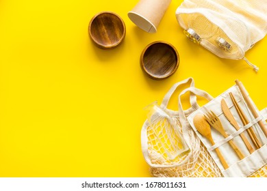 Set Of Reusable Items For Eco-friendly Lifestyle. Cotton Bag, Glass Jars, Wooden Tableware. Zero Waste, Organic Shopping Concept. Yellow Background, Top Down