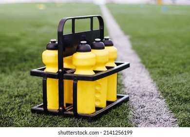 Set of reusable yellow bottles on a soccer field background. - Powered by Shutterstock