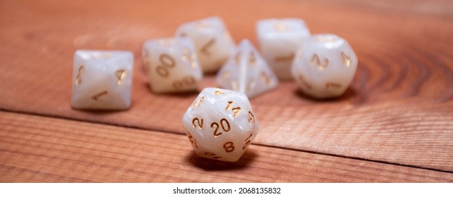 Set of role playing white dices on a gaming table made of wood: banner for Dungeons and Dragons role-playing games