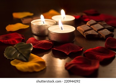 Set Of Romantic Tea Lights With Chocolate and Rose Petals With Blur Background - Powered by Shutterstock