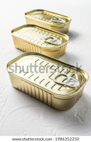 Set of same size close up closed canned food no labels , fish , fruits, vegetables, meat, soup different types of shapes top view onwhite textured background side view vertical.