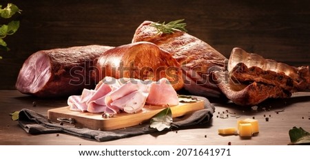 Set of sausages, salami, ham and smoked meats with rosemary cheese and spices on a dark background. Delicacy meat products