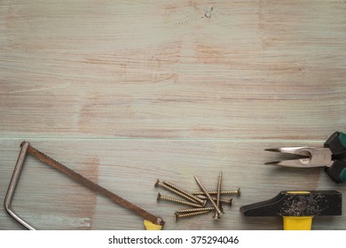 Set of saw, plier, screw and hammer. Tools over a wood panel. Top view with copy space. - Shutterstock ID 375294046