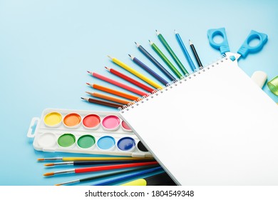A set of school supplies for learning and creative development on a blue background.