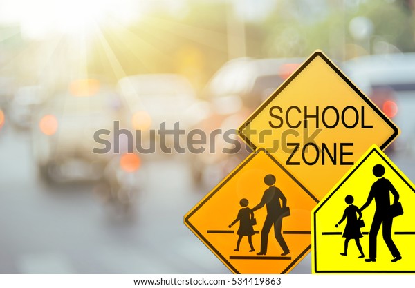 Set of
School zone warning sign on blur traffic road with colorful bokeh
light abstract background. Copy space of transportation and travel
concept. Vintage tone filter color style.
