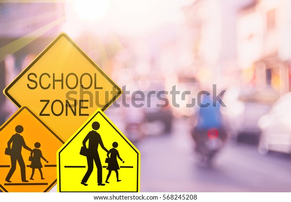 Set of School zone warning sign on blur traffic\
road with colorful bokeh light abstract background. Copy space of\
transportation and travel concept. Vintage tone filter effect color\
style.