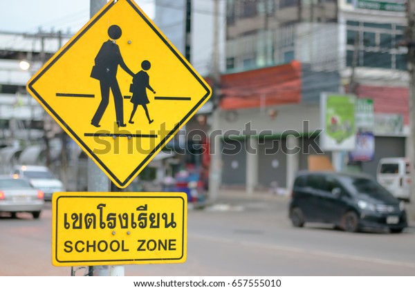 Set of\
School zone warning sign on blur traffic road\
