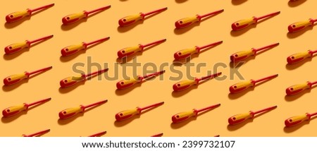 Set of screwdrivers on orange background. Pattern for design