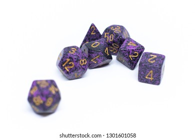 Set with seven purple RPG die isolated on white background: roll playing game. Close up photo.