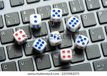 A set of simple small game dice showing different numbers laying on a laptop computer keyboard, random numbers generation, chance, luck, drawing. Randomness, online lottery gambling chances, entropy