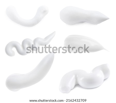 Set with smears of toothpaste on white background