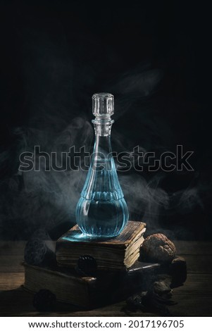 Set of sorcery books and blue magic potion with smoke. Mana potion. Magic and wizardry concept.