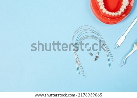 a set of special tools for an orthodontist to install braces for a patient.
Orthodontic arcs, ligature, locks, positioner, tweezers, rubber bands