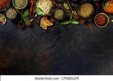 Set of Spices and herbs for cooking. Small bowls with colorful  seasonings and spices - basil, pepper, saffron, salt, paprika, turmeric. On black stone table top view copy space - Shutterstock ID 1792001270