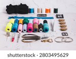A set of spools of multi-colored threads and sewing supplies on a table