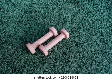 Set Of Sport Accessories On Green Background. Fitness Equipment. Pink Dumbbells. Sport Gear, Close Up