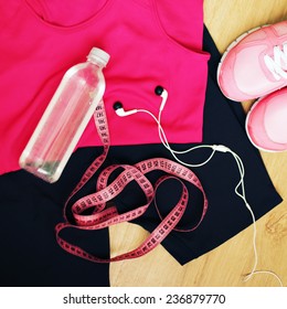 Set For Sports Activities. Running Shoes And Bottle Of Water, Sport Clothes And Earphones Isolated On Wooden Background. Photo Toned Style Instagram Filters. 