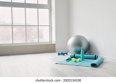 Set of sports equipment with fitness ball near light wall - Powered by Shutterstock